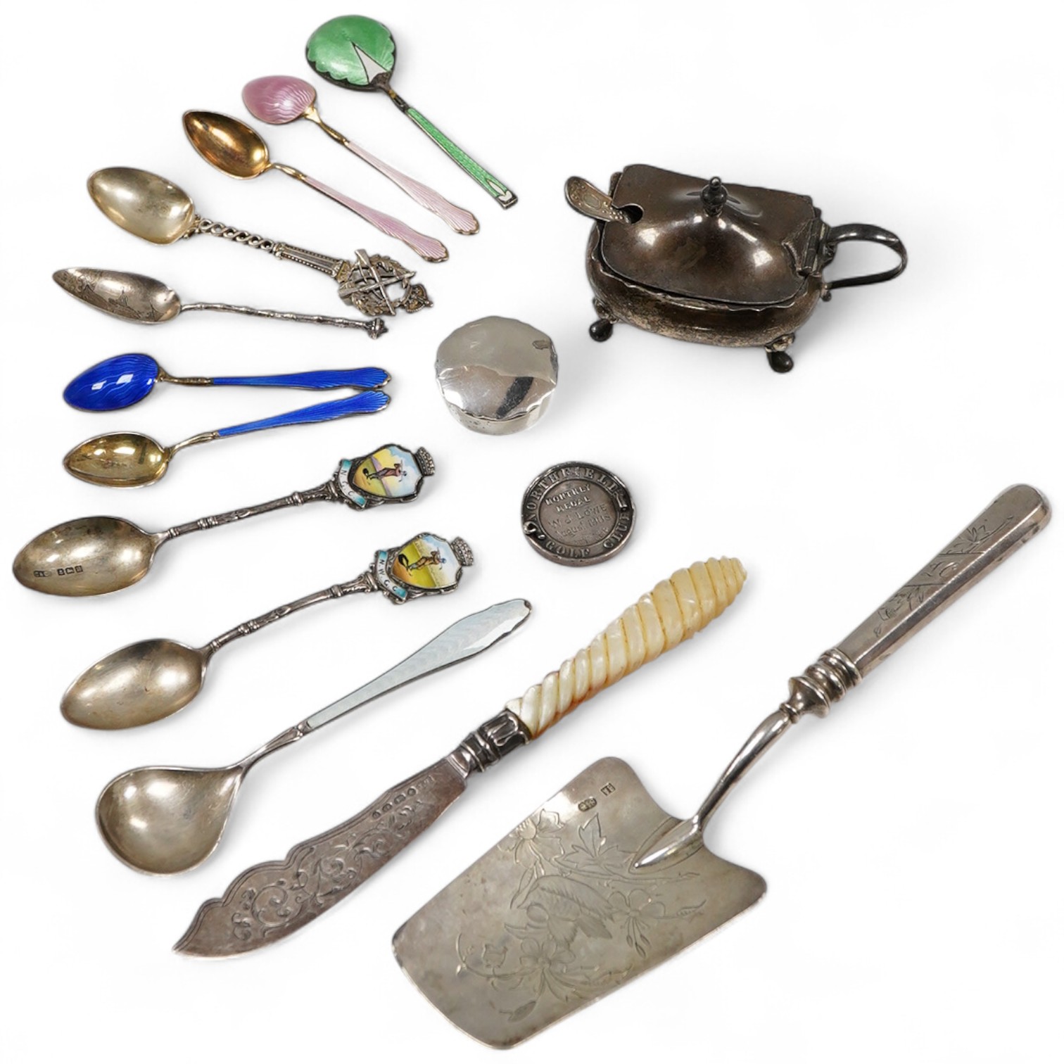 Assorted silverware including a late Victorian mother of pearl handled butter knife, a George V pill box, an Edwardian mustard pot with plated spoon, two enamelled golf related spoons, a rifle shooting related spoon, six